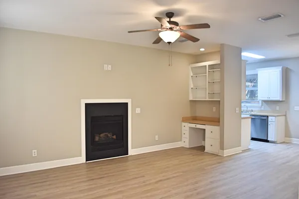 a view of a kitchen with a sink dishwasher a refrigerator and a stove with wooden floor