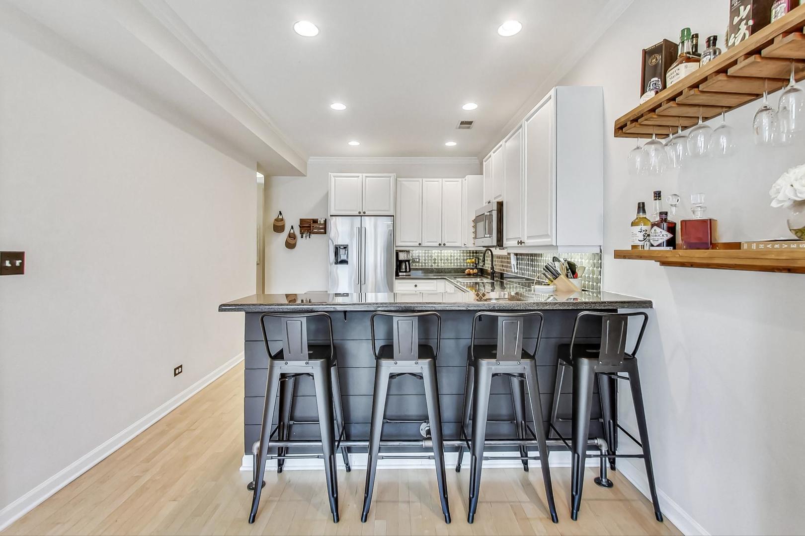 952 West Barry Avenue, Unit 2 Chicago, IL 60657 - Photo 8 of 24 a kitchen with a dining table chairs and white cabinets