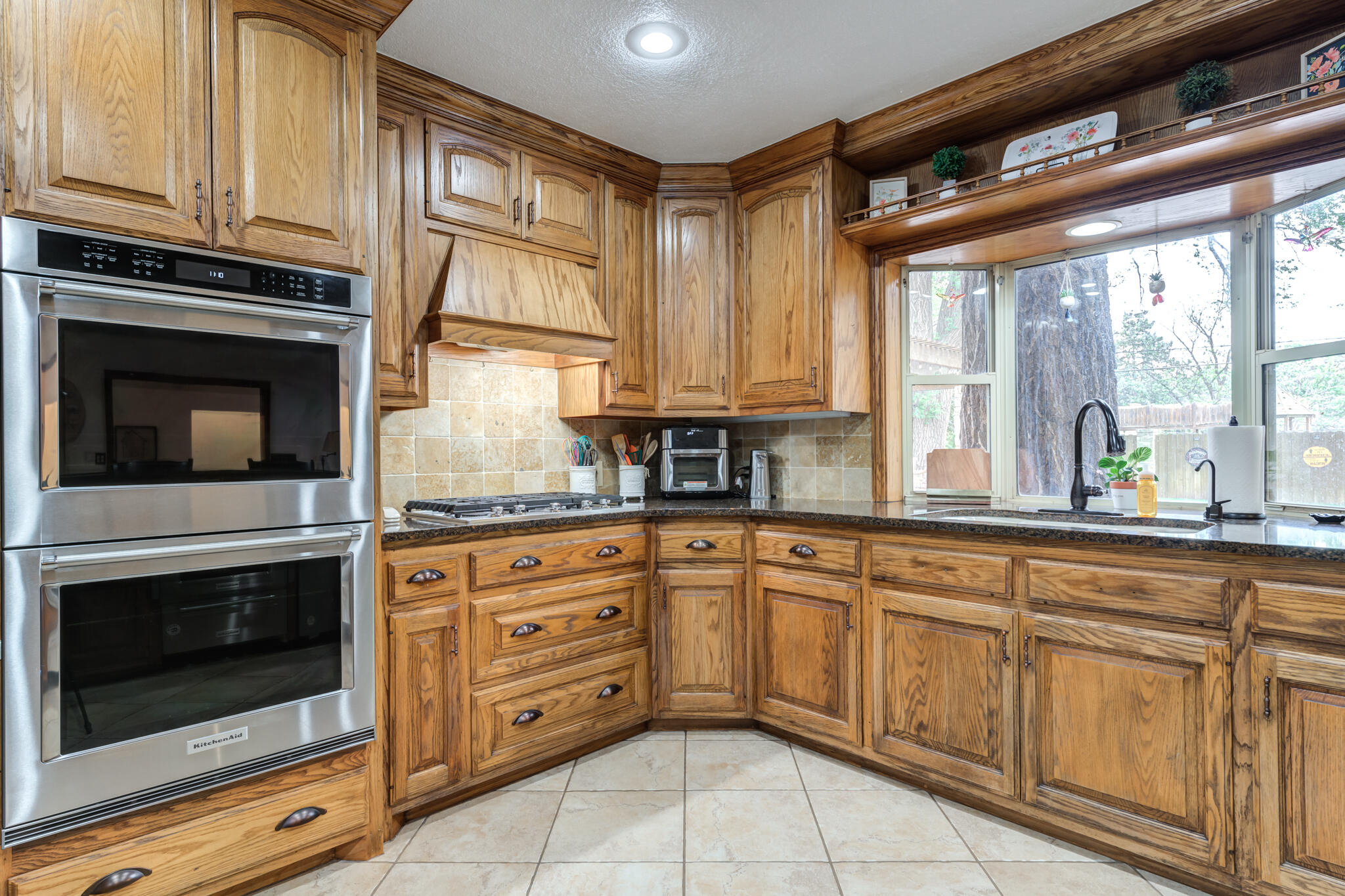 4510 21st Street Lubbock, TX 79407 - Photo 4 of 17 a kitchen with granite countertop white cabinets stainless steel appliances a sink and a window