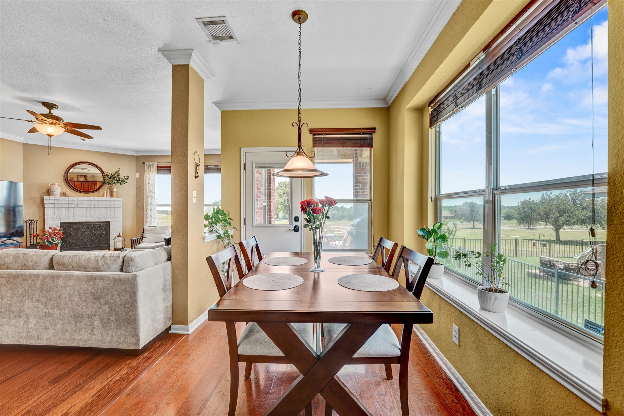 2521 Amen Corner Road Pflugerville, TX 78660 - Photo 11 of 40 Dining area featuring wood-finish flooring, a decorative chandelier, and an expansive window with a broad sill