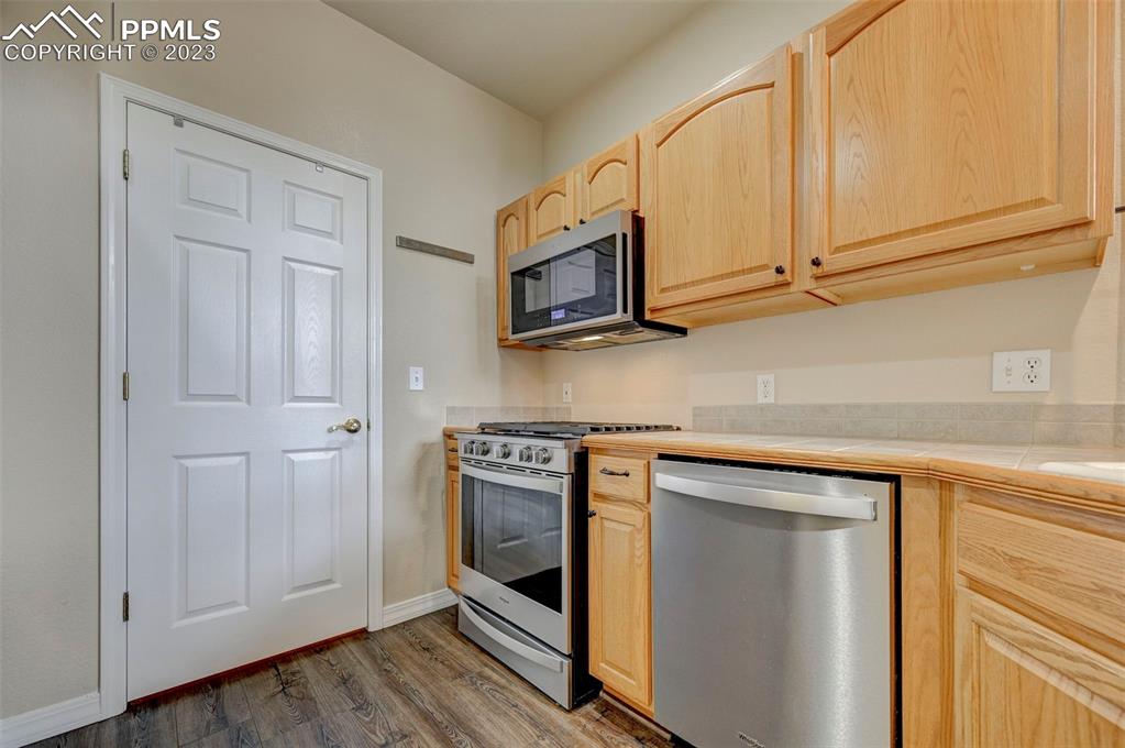 2170 Alpine Shadows View Colorado Springs, CO 80919 - Photo 23 of 49 a kitchen with stainless steel appliances granite countertop white cabinets and sink