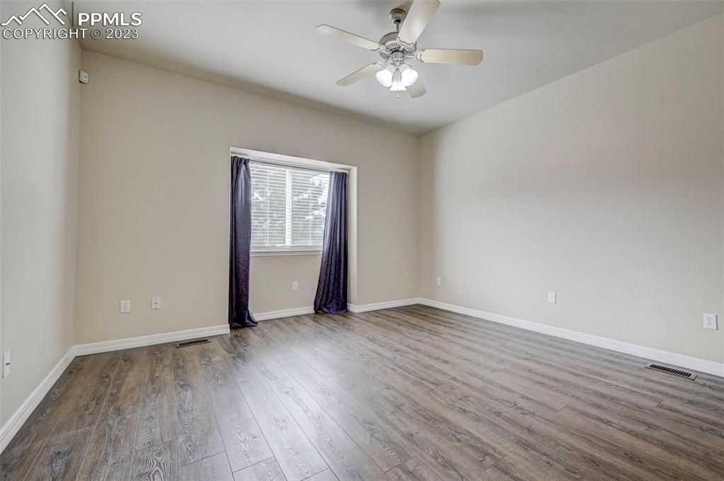 2170 Alpine Shadows View Colorado Springs, CO 80919 - Photo 26 of 49 an empty room with wooden floor chandelier fan and windows