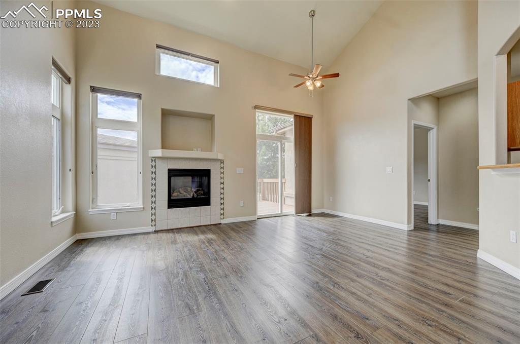2170 Alpine Shadows View Colorado Springs, CO 80919 - Photo 3 of 49 an empty room with wooden floor fireplace and windows