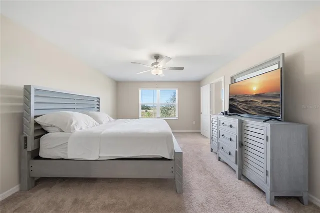 a bedroom with a bed and a flat screen tv on dresser