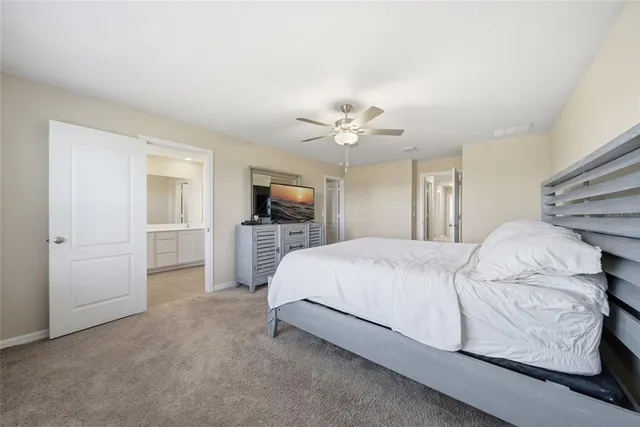 a spacious bedroom with a bed and a flat screen tv