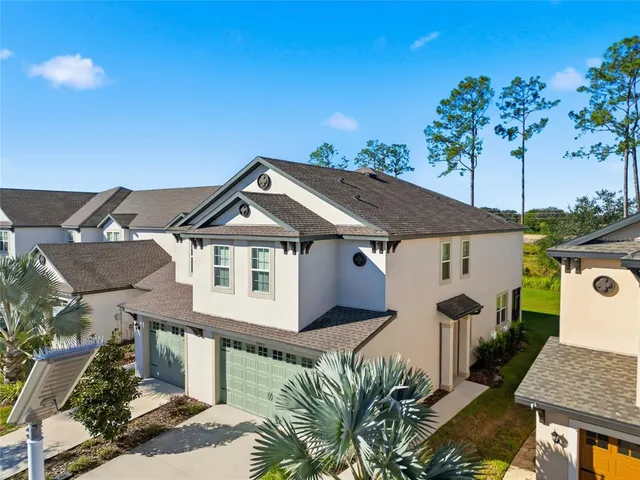 a view of a house with a yard and potted plants