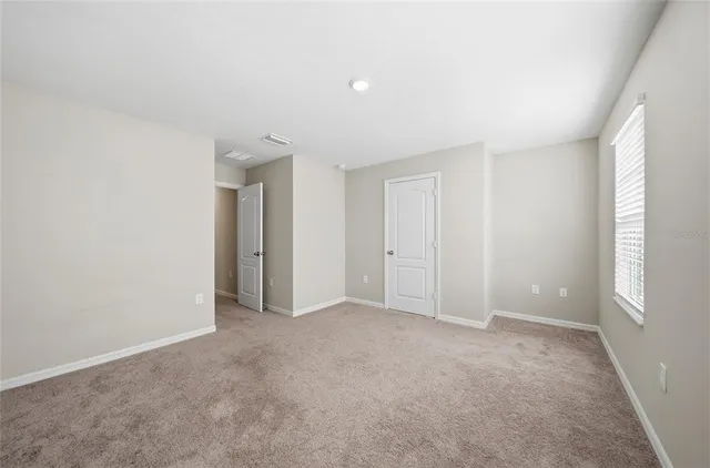 an empty room with windows and closet