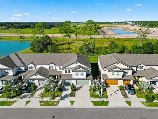 an aerial view of residential houses with outdoor space and ocean view