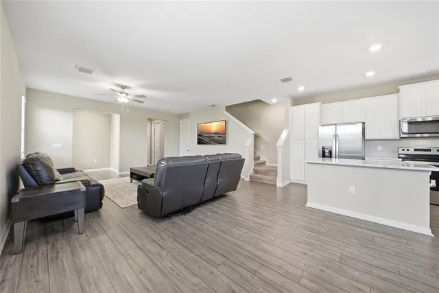 a living room with furniture and a wooden floor