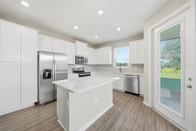 a kitchen with white cabinets and stainless steel appliances