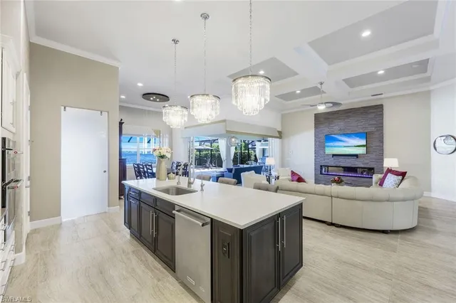 a living room with stainless steel appliances kitchen island furniture and a flat screen tv