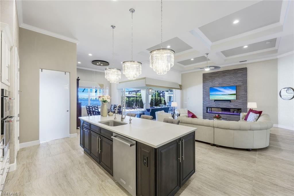 9075 Breakwater Drive Naples, FL 34120 - Photo 11 of 48 a living room with stainless steel appliances kitchen island furniture and a flat screen tv