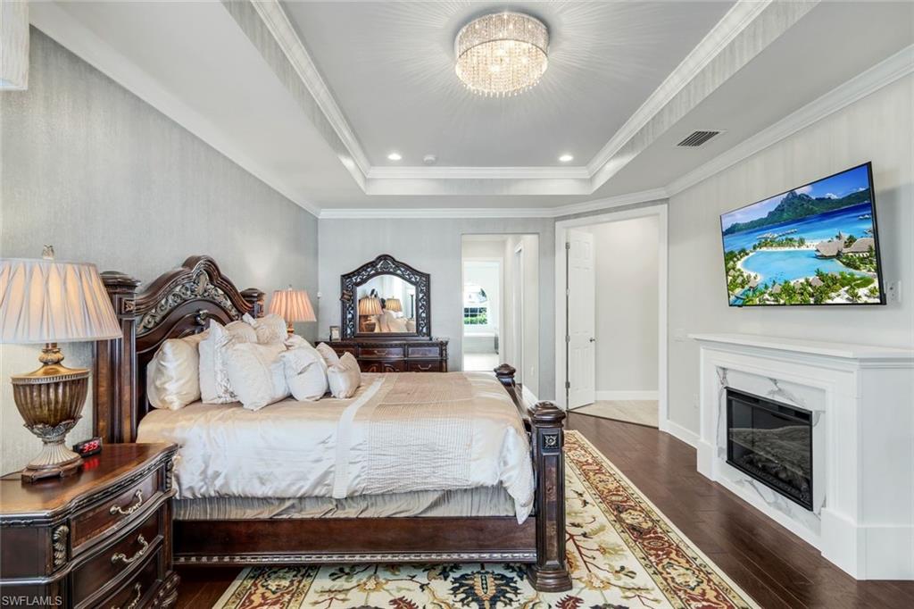 9075 Breakwater Drive Naples, FL 34120 - Photo 15 of 48 a bedroom with a bed and a fireplace