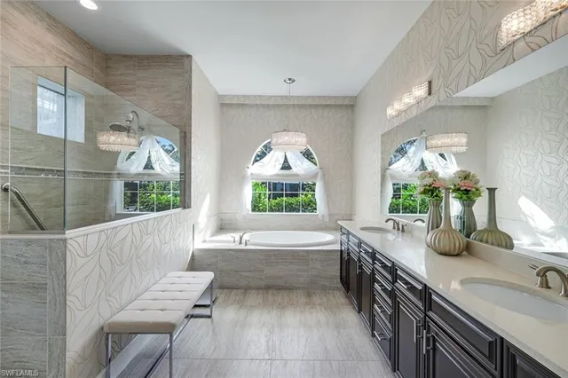a bathroom with a granite countertop tub a double vanity sink and a large mirror