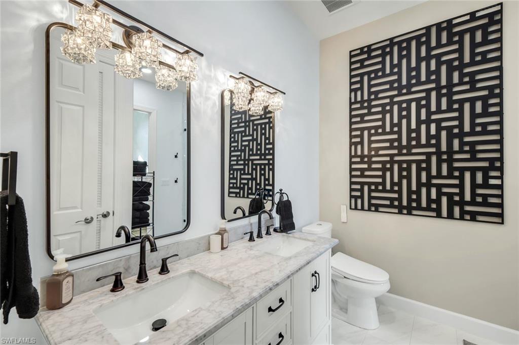 9075 Breakwater Drive Naples, FL 34120 - Photo 25 of 48 a bathroom with a sink and a mirror