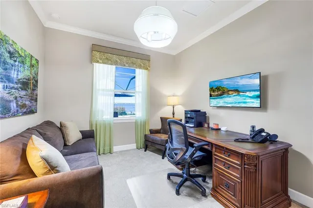 a view of a workspace with furniture and a window