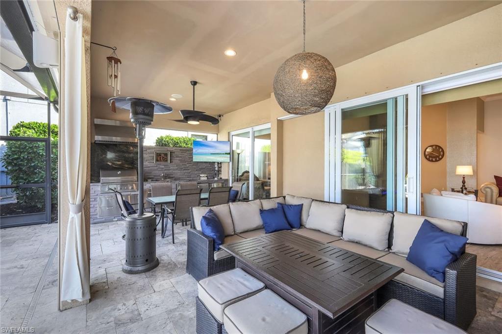 9075 Breakwater Drive Naples, FL 34120 - Photo 28 of 48 a living room with lots of furniture and a chandelier