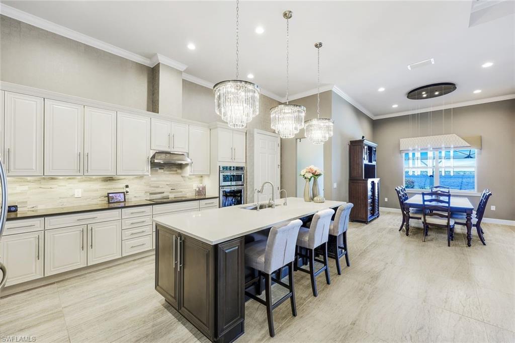 9075 Breakwater Drive Naples, FL 34120 - Photo 10 of 48 a large kitchen with a table and chairs