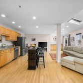 a living room with stainless steel appliances furniture and a kitchen view