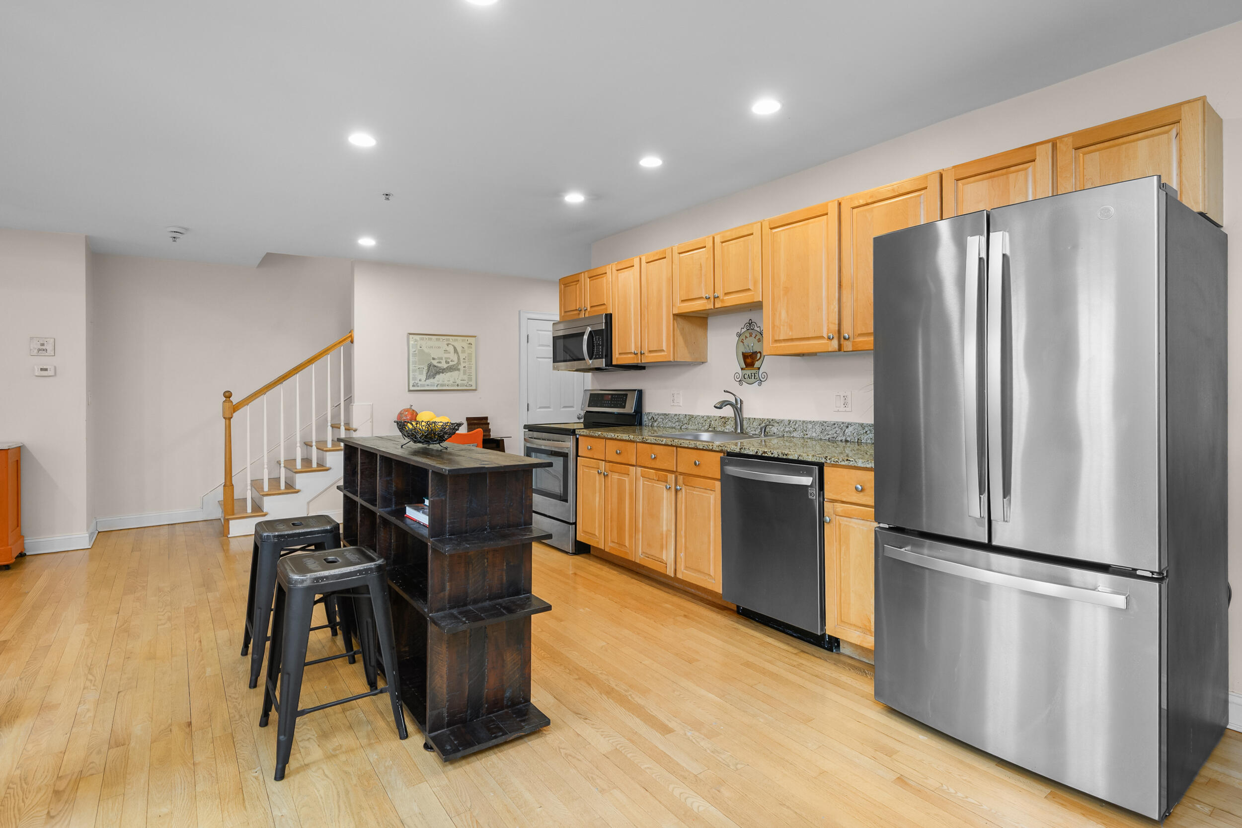 615 Main Street, Unit 3 Hyannis, MA 02601 - Photo 5 of 22 a kitchen with a refrigerator a microwave oven dining table and chairs