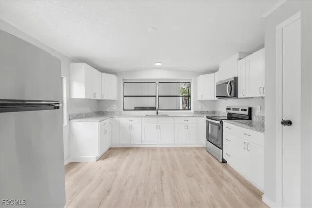 a kitchen with white cabinets and white appliances
