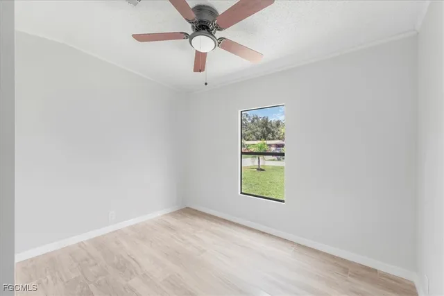 an empty room with window and ceiling fan