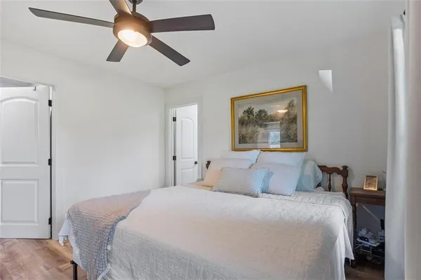 a bedroom with a large bed and a painting on the wall