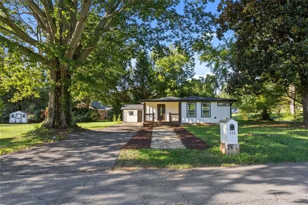 a front view of a house with yard and green space