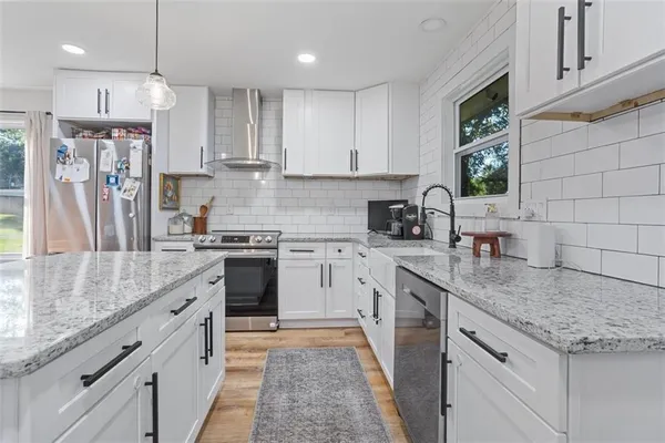 a kitchen with stainless steel appliances granite countertop a sink stove and refrigerator