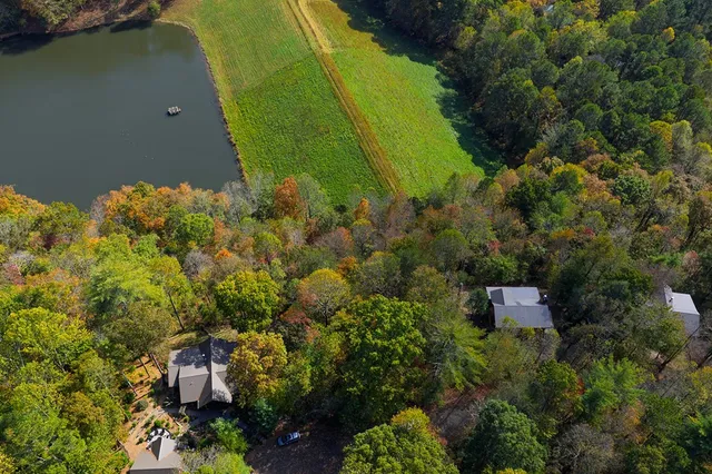 an aerial view of a house with a yard and lake view