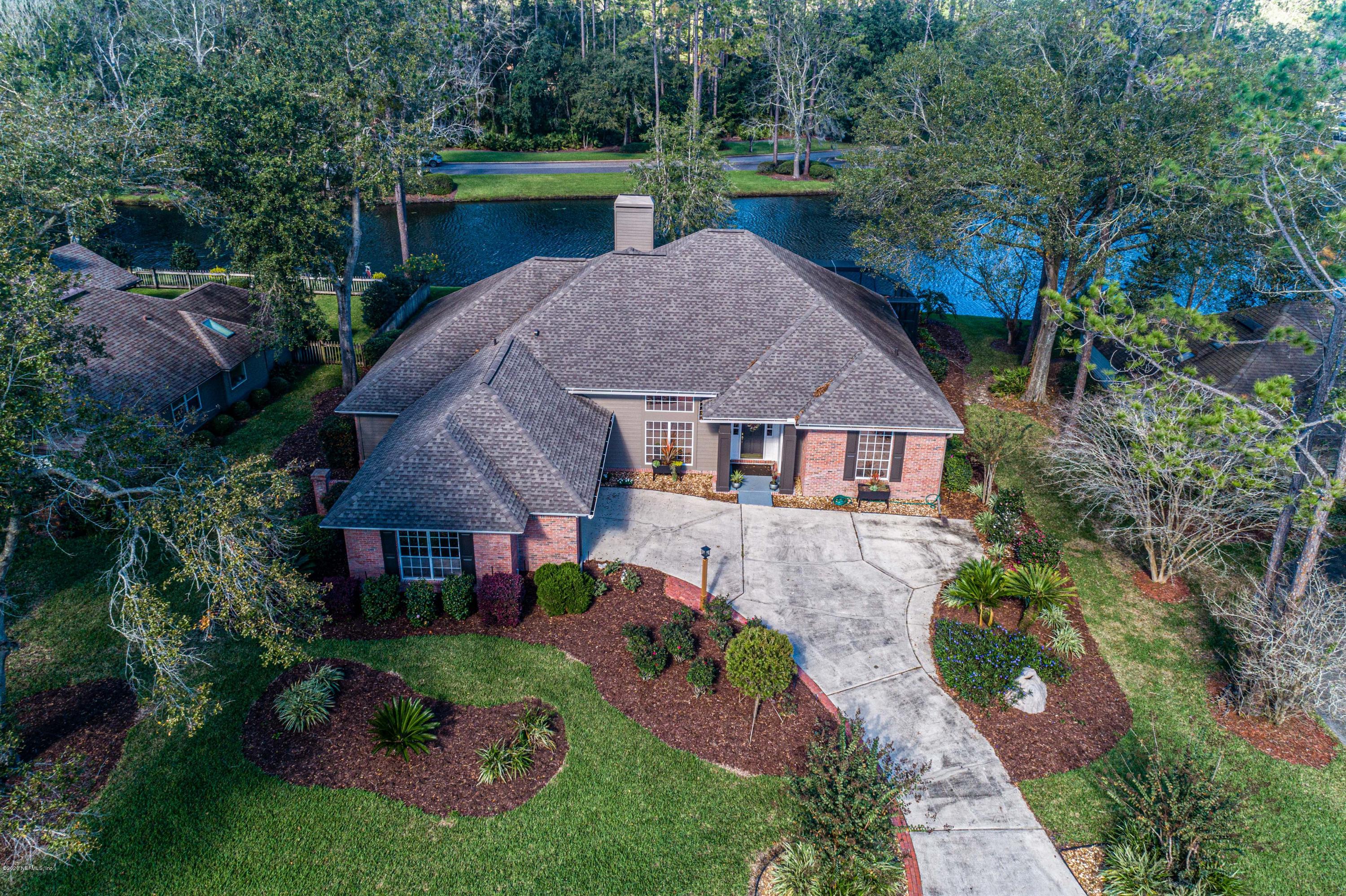 a aerial view of a house with a yard plants and large tree