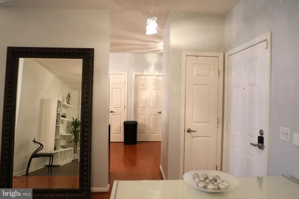 a view of a livingroom with wooden floor and a refrigerator