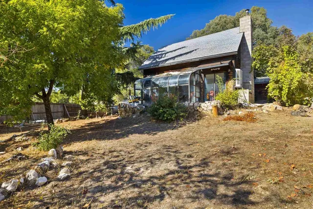 a view of a house with a tree in front of it