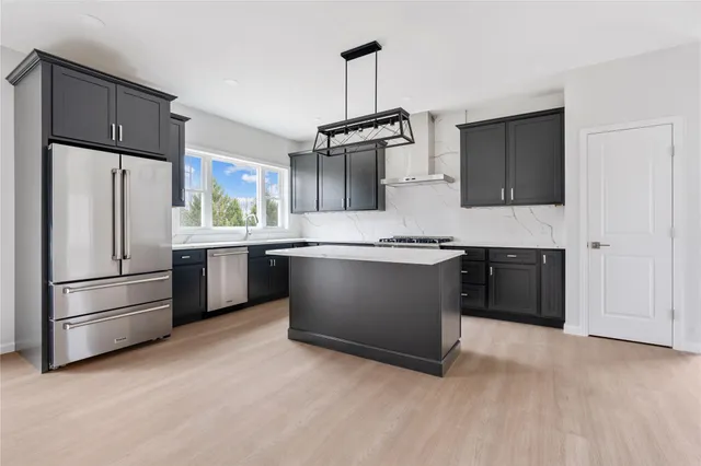 a kitchen with stainless steel appliances a refrigerator sink and cabinets