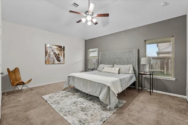 a spacious bedroom with a bed and a chair