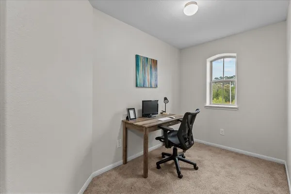 a view of a workspace with furniture and a mirror