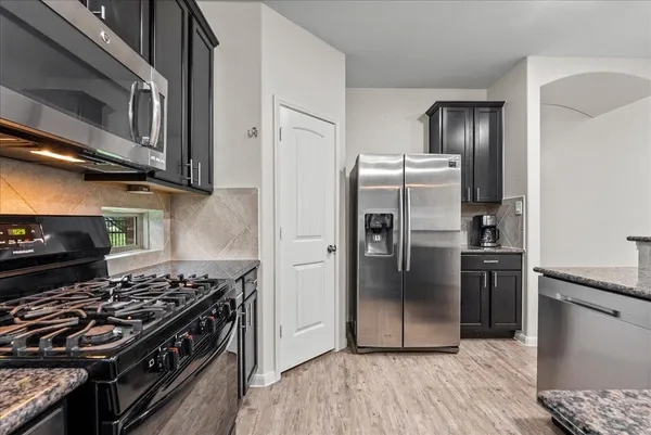 a kitchen with stainless steel appliances granite countertop a stove and a refrigerator