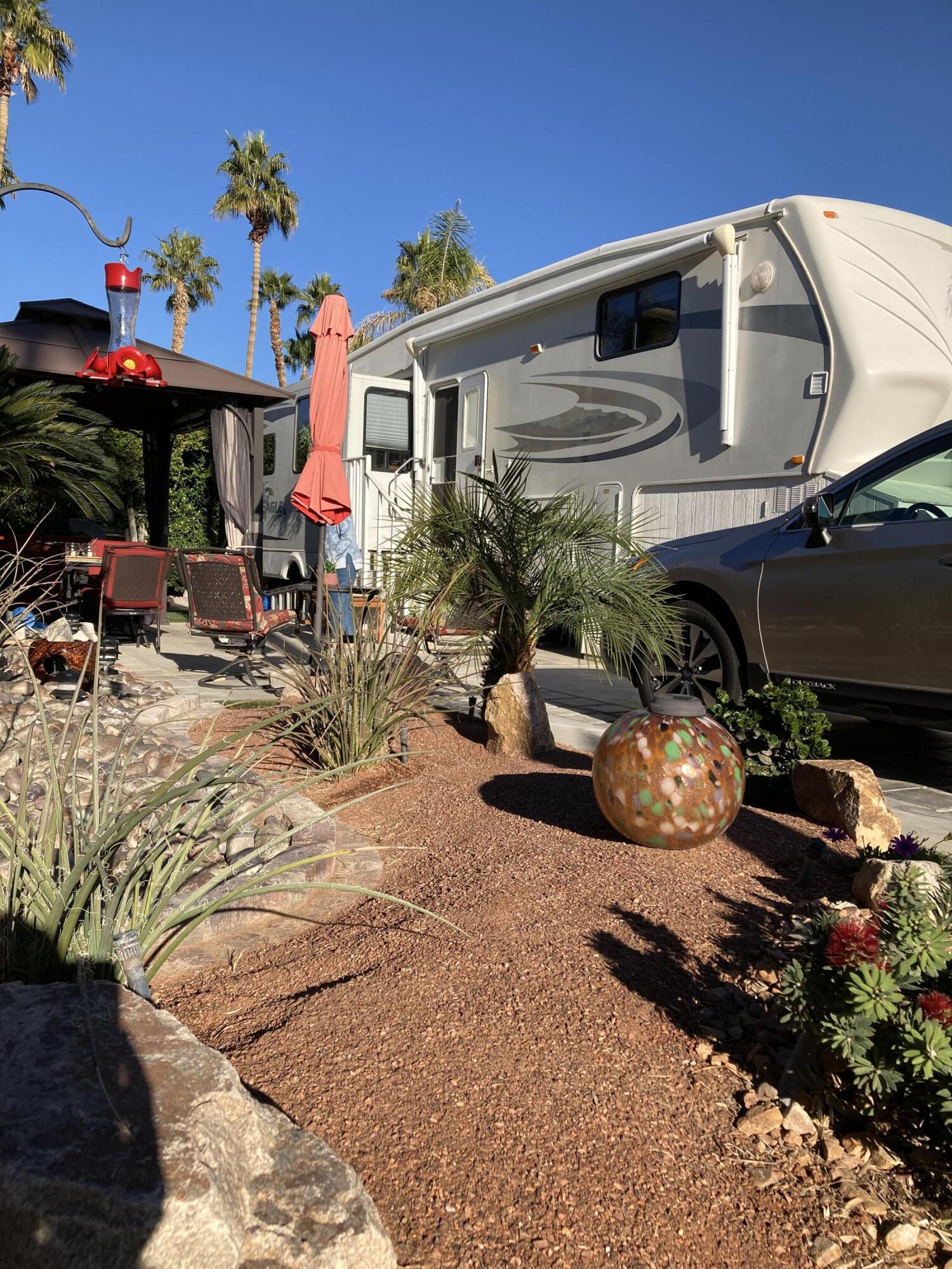 69411 Ramon Road, Unit 61 Cathedral City, CA 92234 - Photo 1 of 14 a front view of a house with yard and sitting area