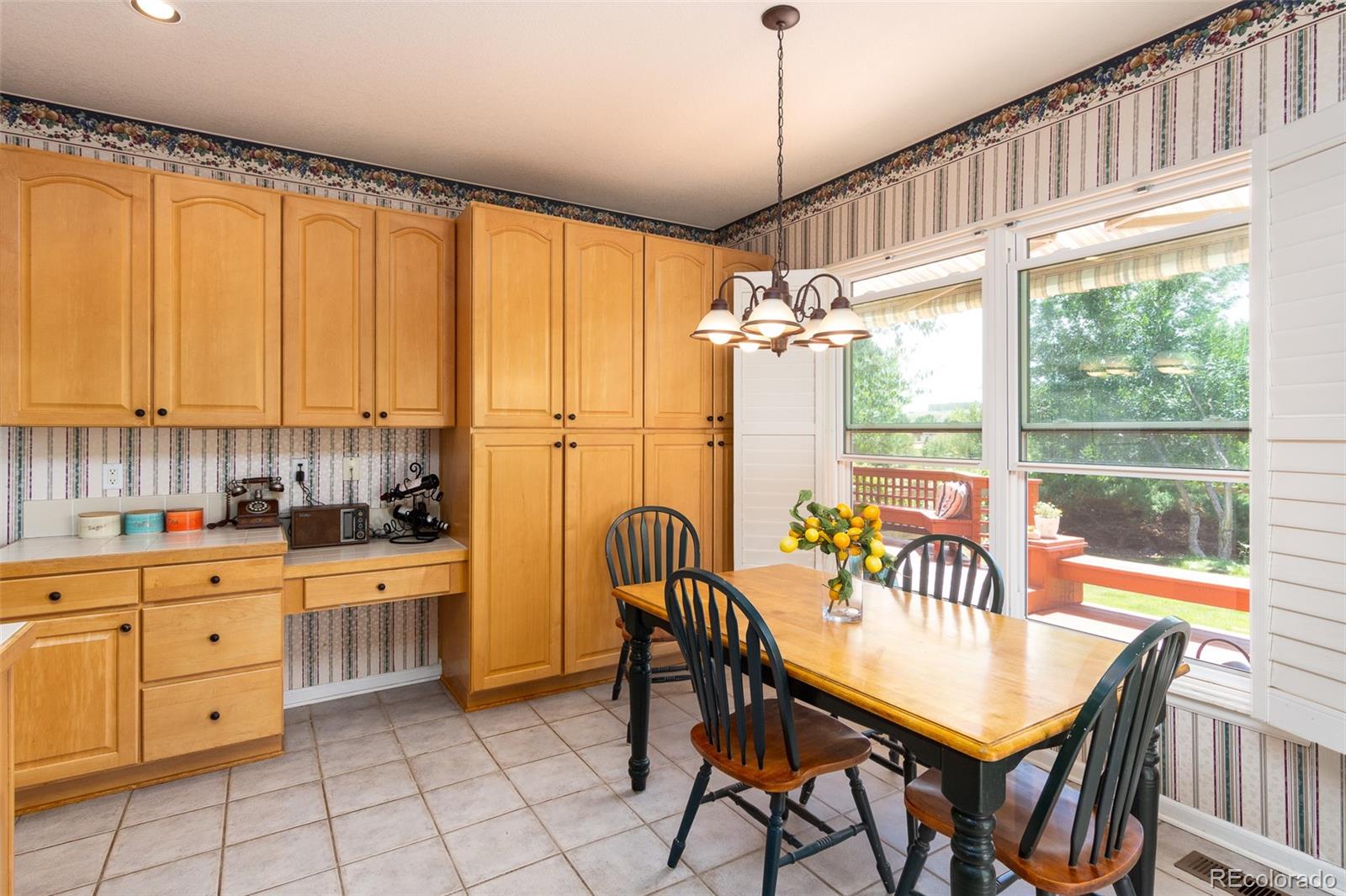 1082 Eldorado Drive Superior, CO 80027 - Photo 11 of 40 a kitchen with stainless steel appliances granite countertop a stove a refrigerator a sink a dining table and chairs with wooden floor