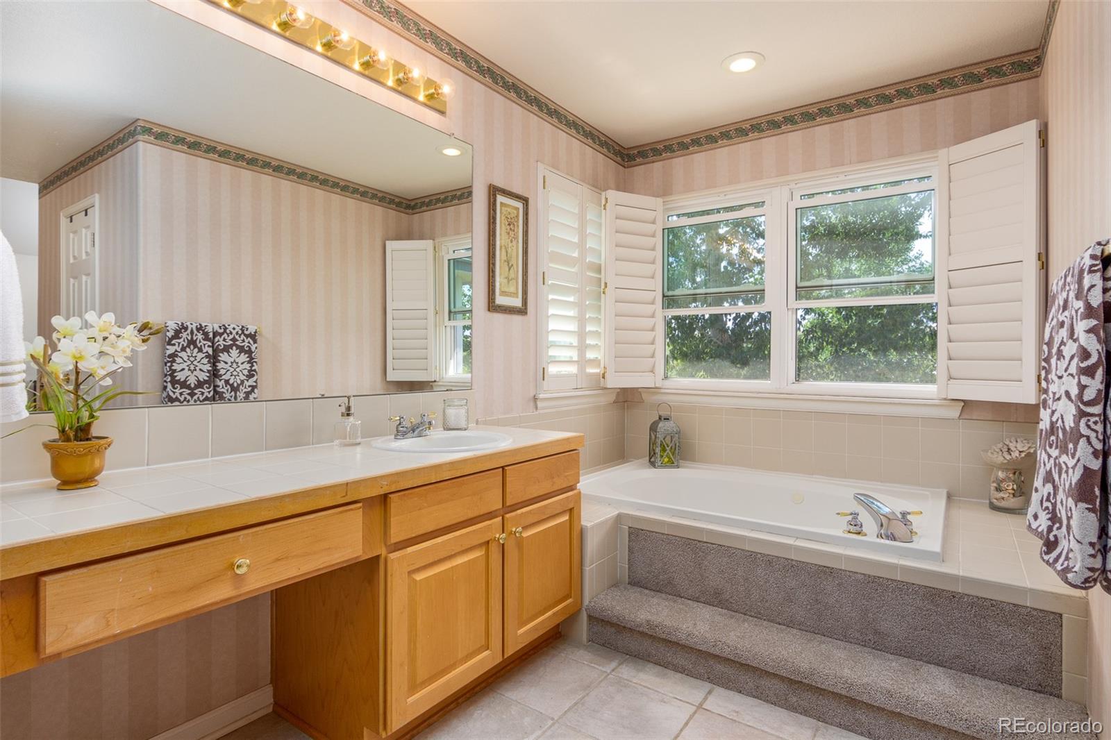 1082 Eldorado Drive Superior, CO 80027 - Photo 29 of 40 a bathroom with a granite countertop sink and a bathtub next to a window