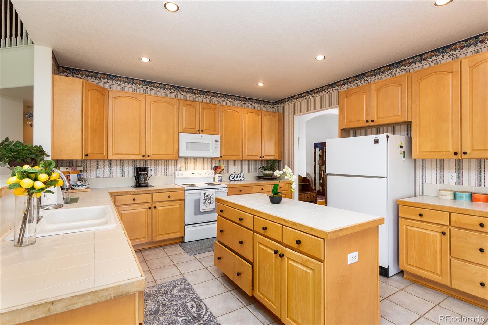 1082 Eldorado Drive Superior, CO 80027 - Photo 10 of 40 a kitchen with white cabinets and white appliances