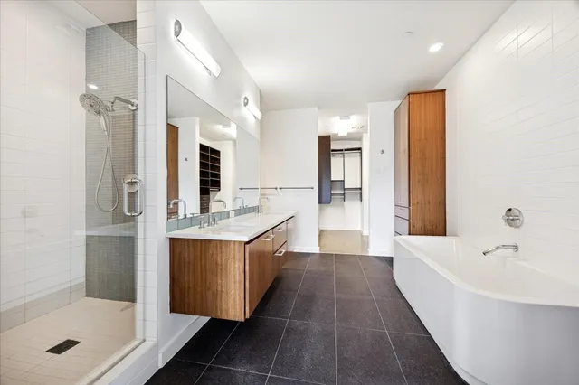 a bathroom with a tub sink shower and mirror