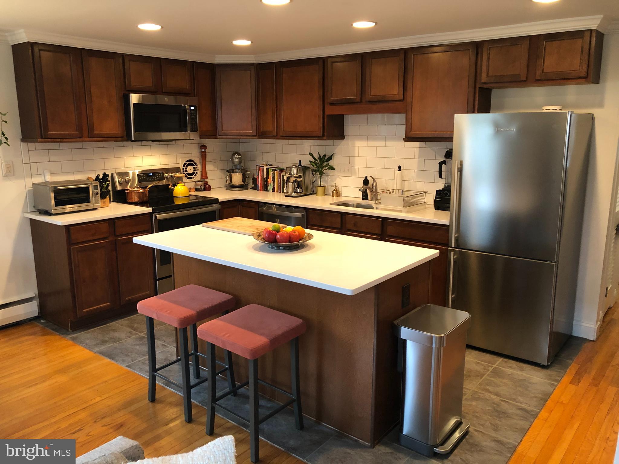 61 Llanfair Road, Unit A1 Ardmore, PA 19003 - Photo 3 of 9 a kitchen with stainless steel appliances a refrigerator stove microwave and cabinets