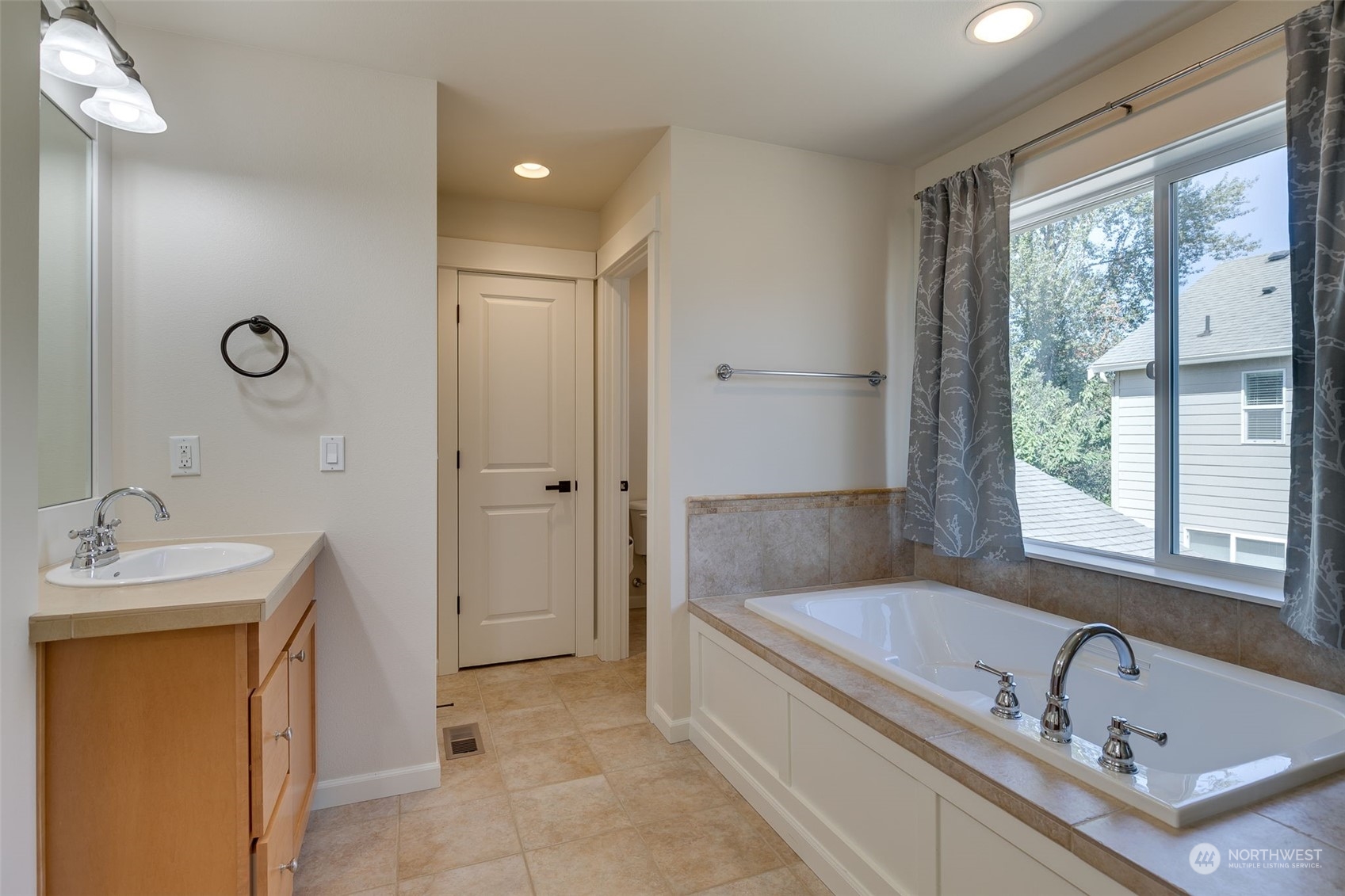 571 Lyons Place Northeast Renton, WA 98059 - Photo 17 of 27 a bathroom with a tub sink and mirror