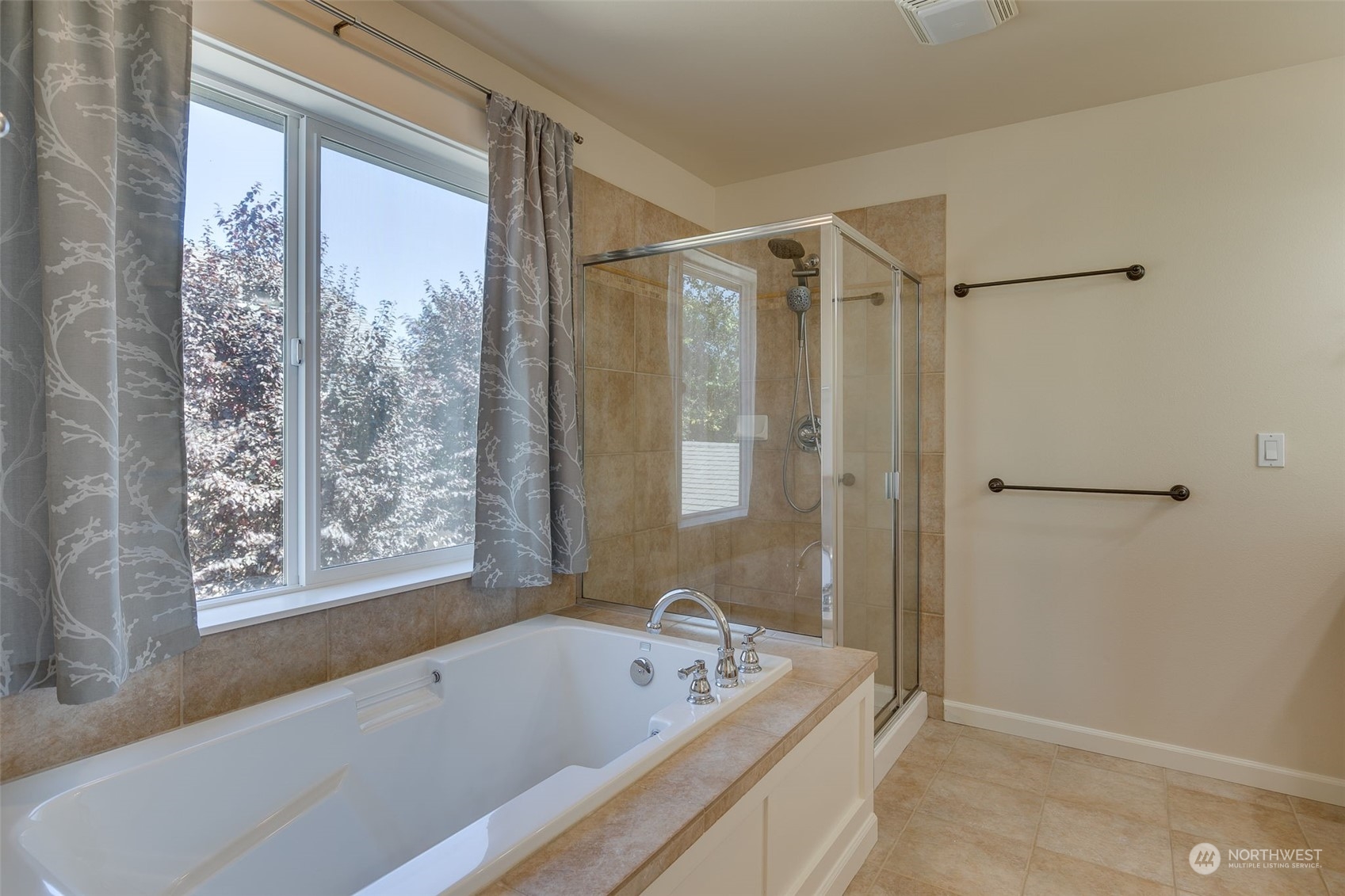 571 Lyons Place Northeast Renton, WA 98059 - Photo 18 of 27 a bathroom with a tub a window and a shower