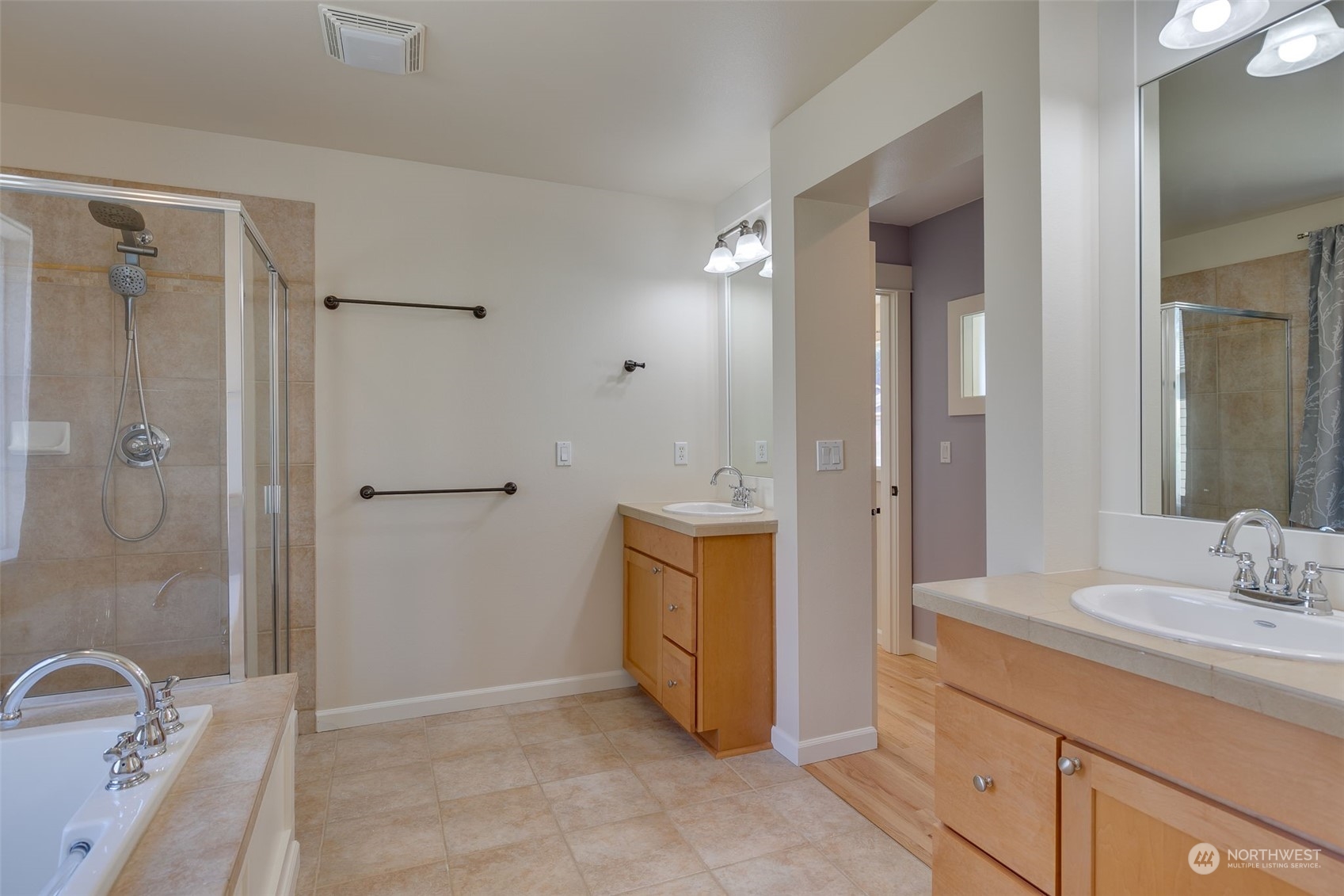571 Lyons Place Northeast Renton, WA 98059 - Photo 19 of 27 a bathroom with a double vanity sink a mirror and a bathtub