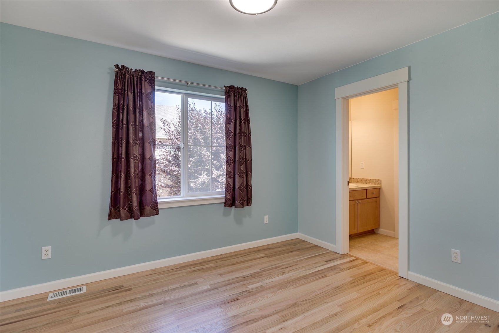 571 Lyons Place Northeast Renton, WA 98059 - Photo 23 of 27 a view of an empty room with wooden floor and a window