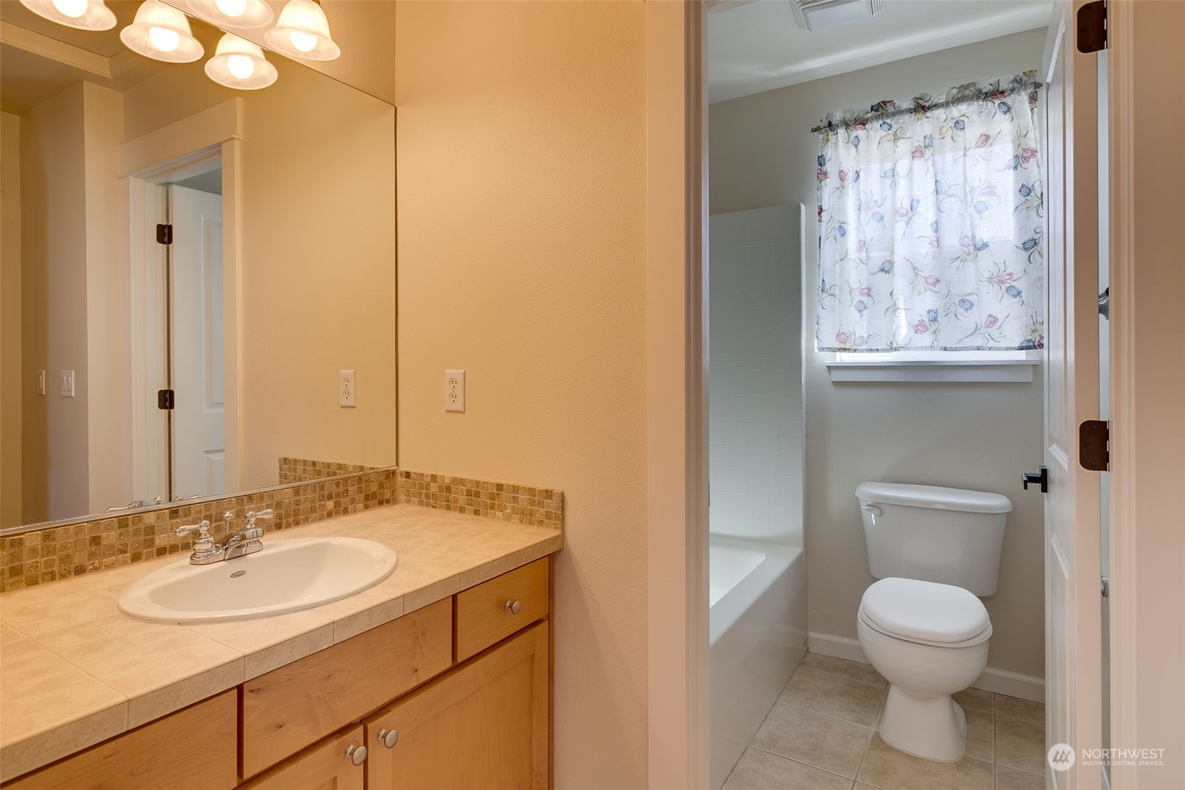 571 Lyons Place Northeast Renton, WA 98059 - Photo 24 of 27 a bathroom with a toilet a sink and a mirror
