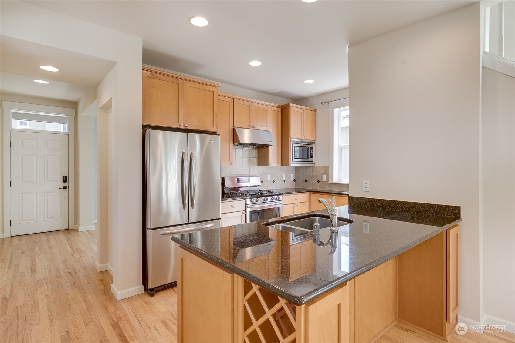 571 Lyons Place Northeast Renton, WA 98059 - Photo 4 of 27 a kitchen with stainless steel appliances granite countertop a sink a refrigerator and a stove top oven