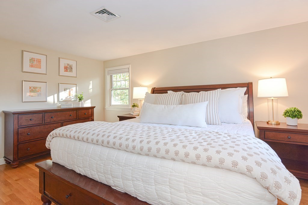 7 Tamarack Road Medfield, MA 02052 - Photo 14 of 33 a bedroom with a large bed and wooden floor